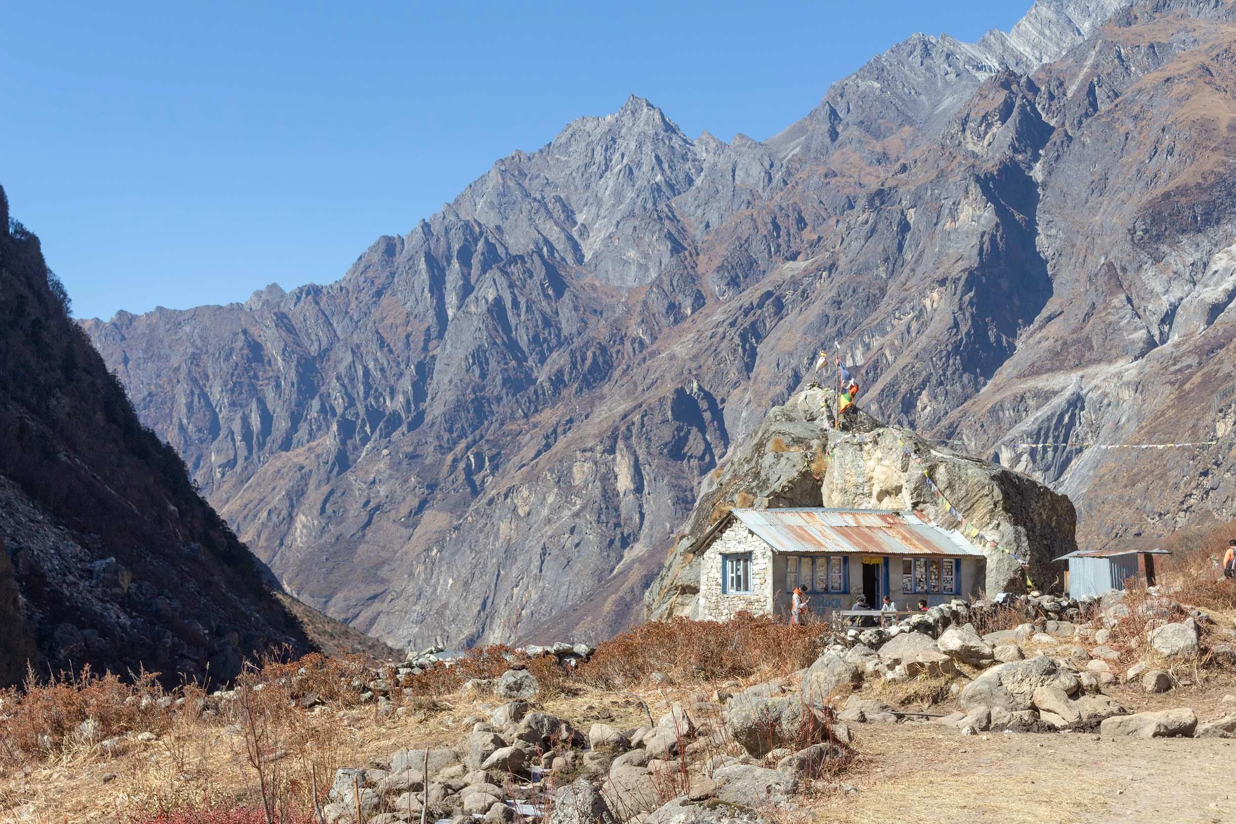 View of the Langtang Valley (Nepal) surrounded by mountains. In the front there is a small traditional house