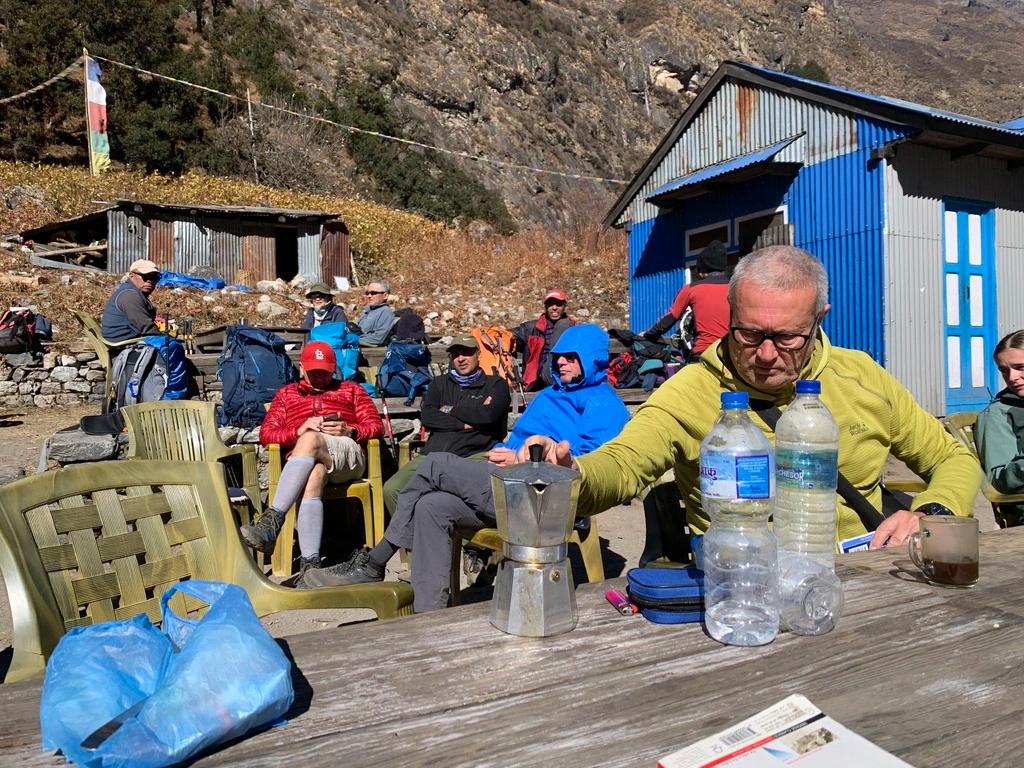 Gruppo di trekker italiani che si versano il caffè della moka davanti ad una baita