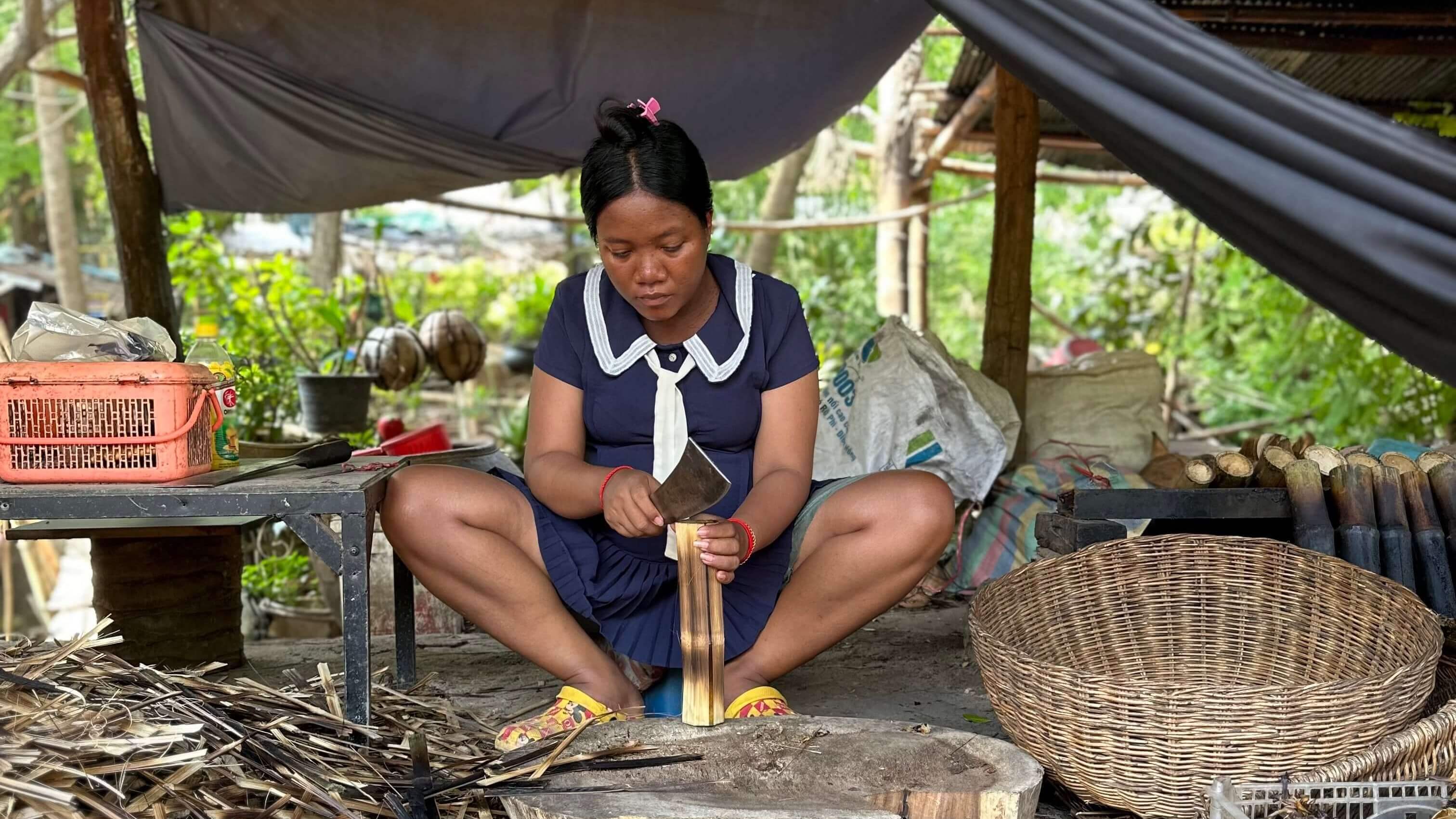 Una donna che taglia il cocco per lo sticky rice. La scena è ambientata Battambang, in Cambogia
