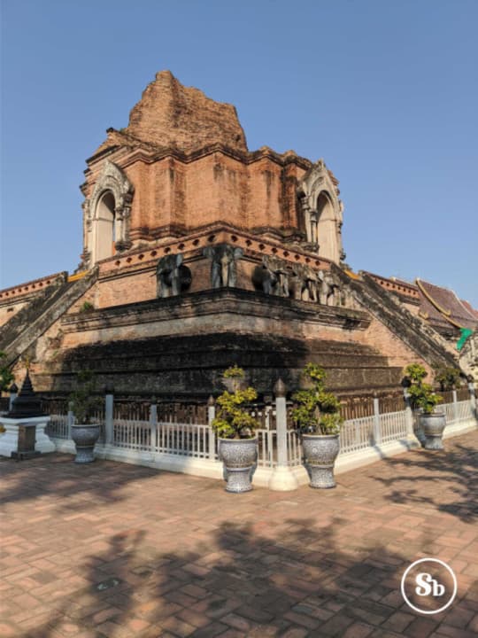 Wat Chedi Luang, Chiang Mai Vista di Wat Chedi Luang da uno degli angoli. Il tempio è parzialmente in rovina, ma si riescono comunque ad intravedere delle statue di elefante sia nei lati che nell'angolo. Il tempio è principalmente composto di mattoncini rossi. Nella parte superiore ci sono due archi, uno per lato, di color bianco-grigoignolo.