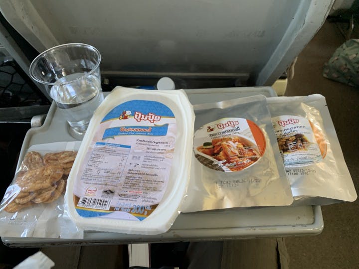 Our meal in the train. From left to right: banan chips, rice, panang curry chicken, mackerel